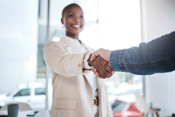Black woman, handshake and meeting in partnership, support or trust for teamwork or unity at office. African female person or employee shaking hands for introduction, agreement or deal at workplace